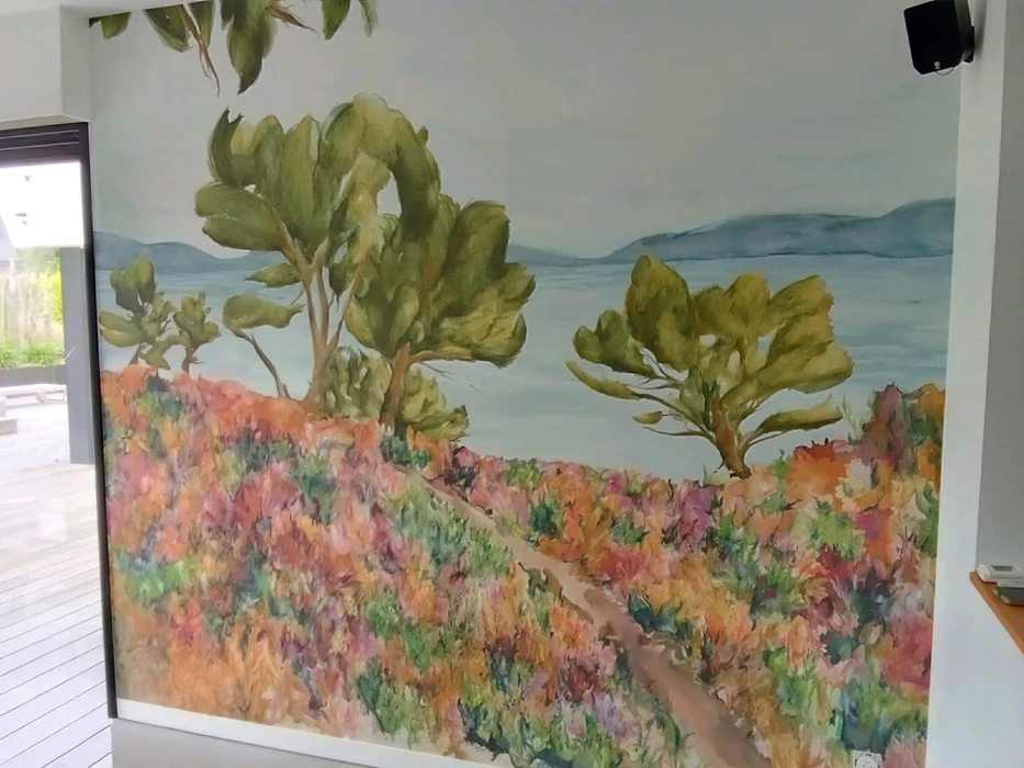 Chantier de rénovation intérieure en cours avec mur accent peint en terre cuite orange dans une pièce aux murs blancs. Prises électriques et interrupteurs noirs installés, câbles apparents en attente de finition. Sol protégé par bâche plastique.