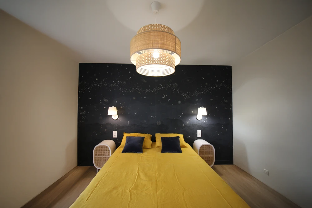 Intérieur résidentiel moderne avec mur d'accent orange terracotta contrastant avec murs blancs. Porte d'entrée sombre à gauche, grandes baies vitrées à cadre noir donnant sur l'extérieur à droite.