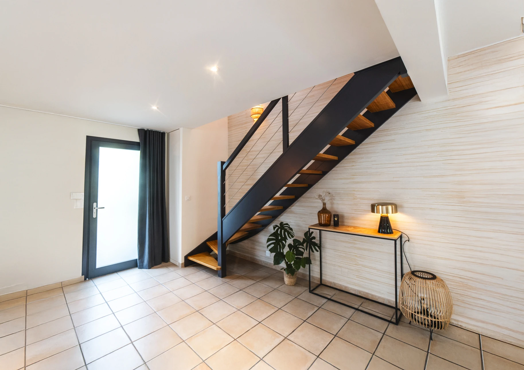 Une main masculine saisit fermement la main courante d'un escalier intérieur en bois