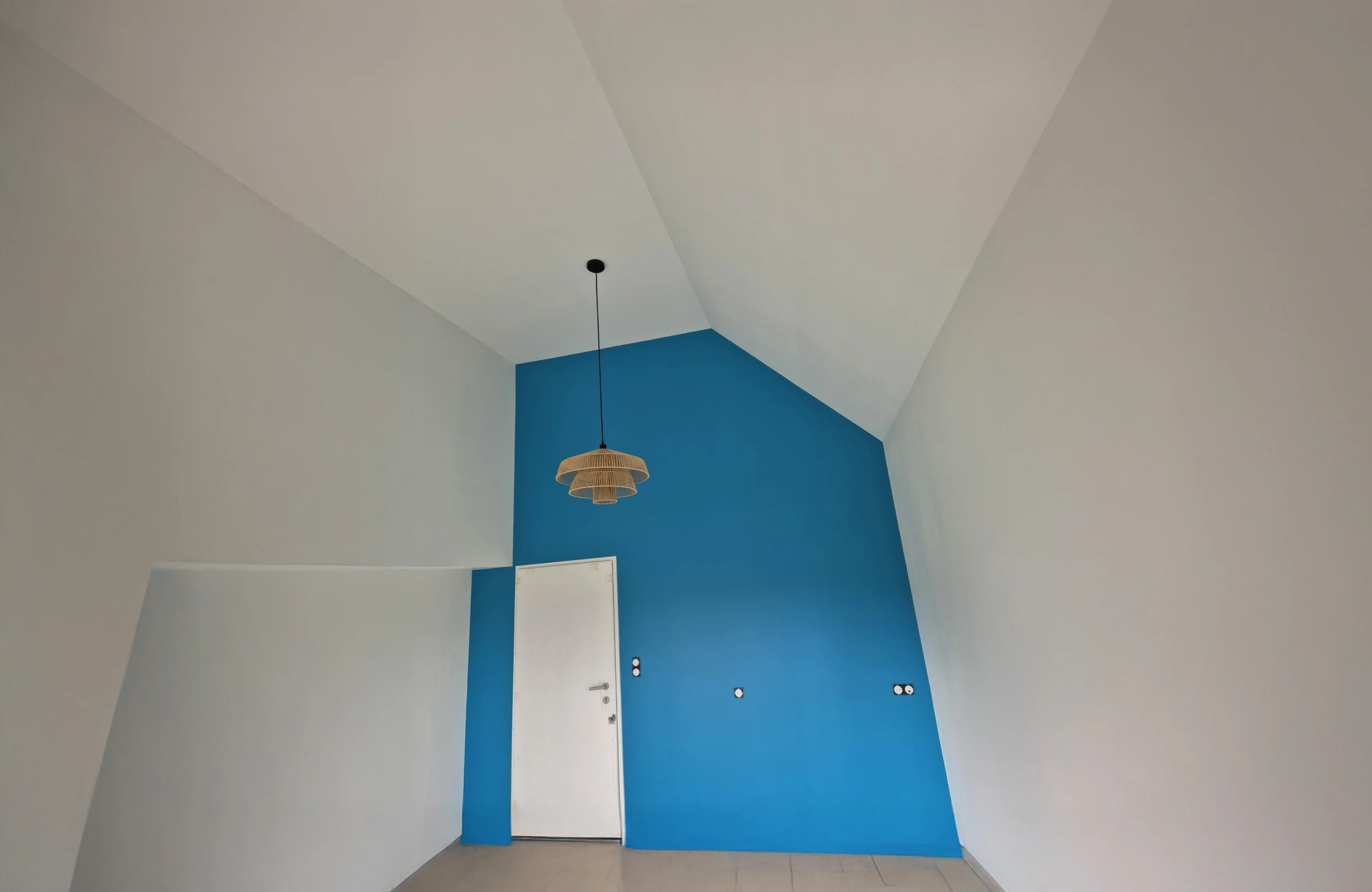 Travailleuse appliquant une blancheur blanche au plafond à l'aide d'un rouleau de poignée à la maison